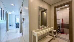 A modern bathroom with a glass shower enclosure, a large mirror, and a white vanity. - The Lofts Central, Burj khalifa View (Dubai)