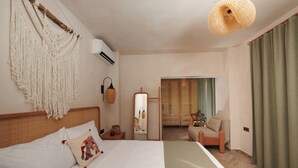 Habitación de hotel con una cama, una silla, un espejo y vistas a un balcón.
