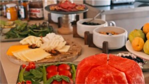 Un bufé con diversos alimentos, incluyendo frutas, verduras y quesos.