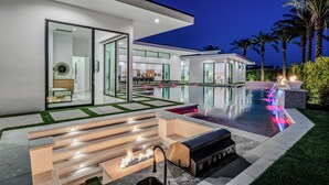 A modern house with a swimming pool, outdoor seating, and a fire feature. - Sleeps 17 • Private Pool + Hot Tub + Pickleball Court • Near La Quinta | Bravo (Indio)