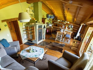 Ein gemütliches Blockhaus-Interieur mit Wohnbereich, Küche und Essbereich.