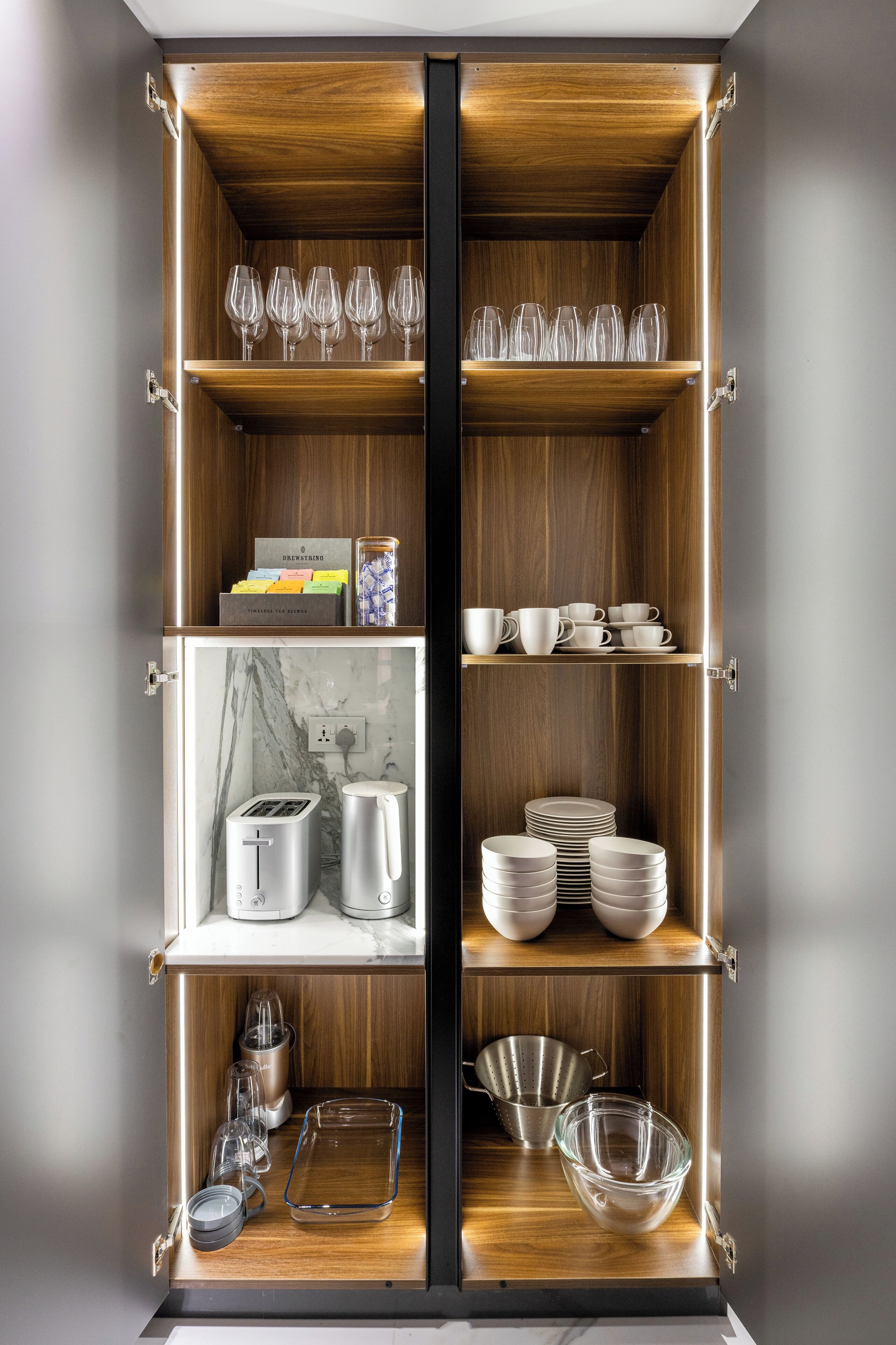 A kitchen with wooden cabinets, a marble countertop, and various kitchen appliances.
