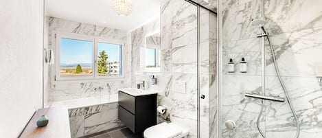 Exclusieve penthouse | Badkamer | Een douche, een haardroger, handdoeken, zeep