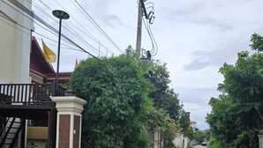 A residential street with houses on both sides, a clear road, and some greenery. - ALI XAYATHIT APARTMENT & HOTEL (Vientiane)
