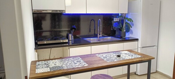 Een koffiezetapparaat/waterkoker, kookgerei, borden en bestek