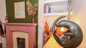 Une pièce avec une cheminée, une table en bois et une sculpture.