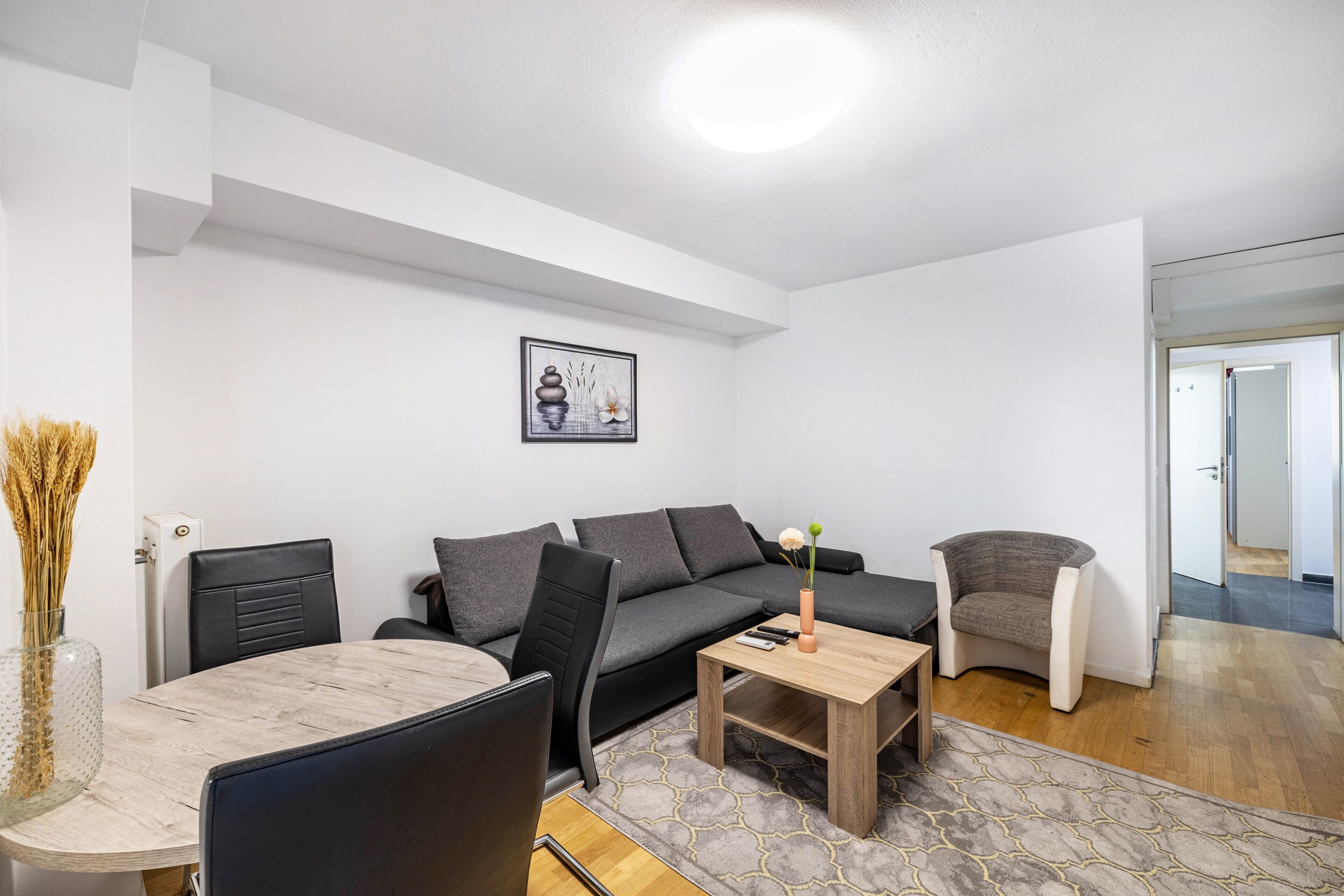 Una sala de estar moderna con sofá, sillas, una mesa de centro y una mesa de comedor.