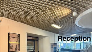 A reception area with a patterned ceiling, a bench, a door, and a staircase. - City Center Retreat/ 1 min Train Station (Köln)