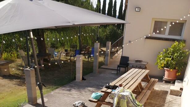 Ein Whirlpool mit zwei Personen, eine überdachte Terrasse, Gartenmöbel und ein Garten.