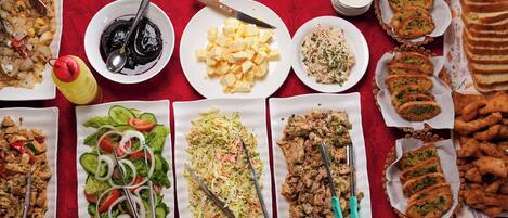 A table with various dishes including salads, meats, and bread.