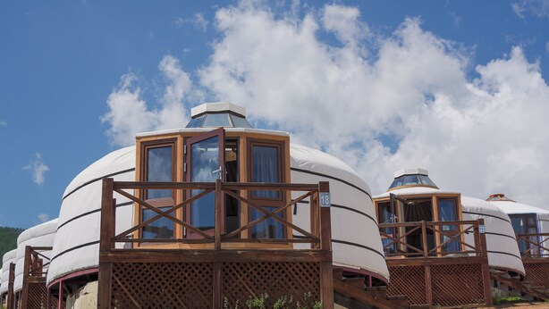 Yurts with wooden frames and windows, set against a clear sky. - Bayankhad Star Lodge (Ulaanbaatar)