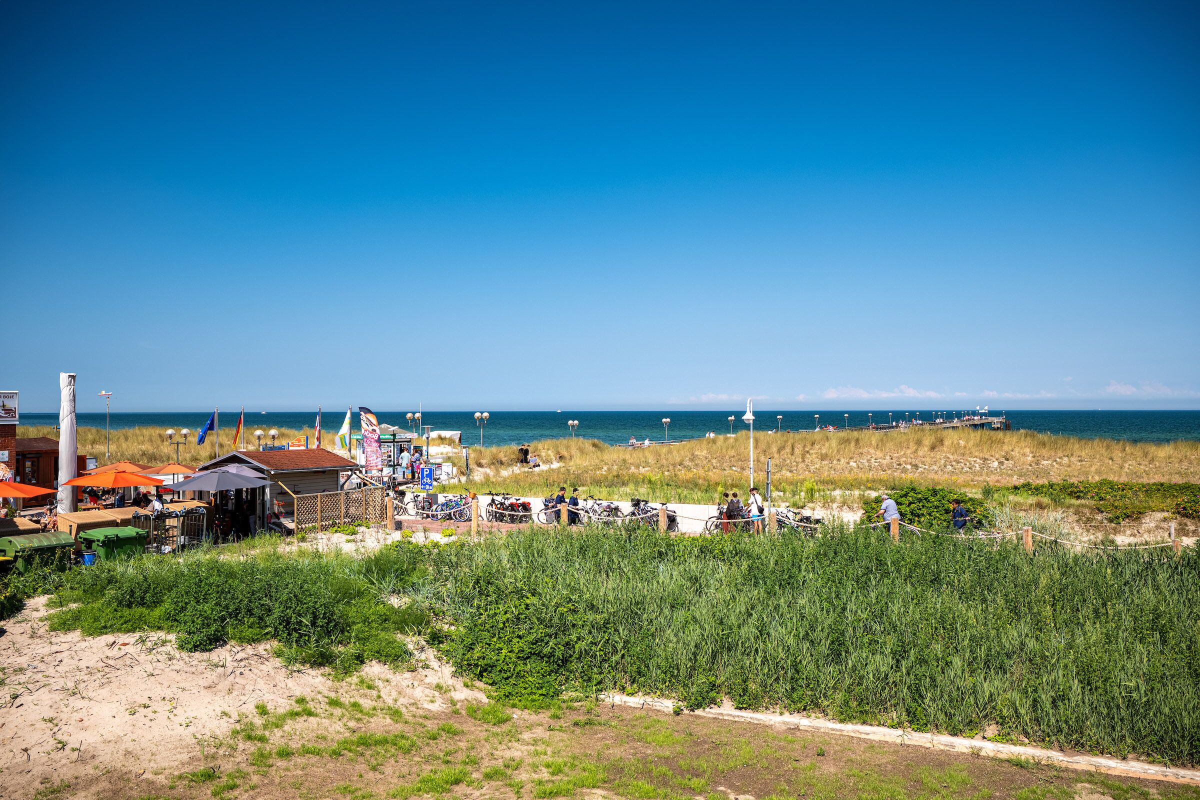 A coastal area with buildings, a beach, and the sea in the background.