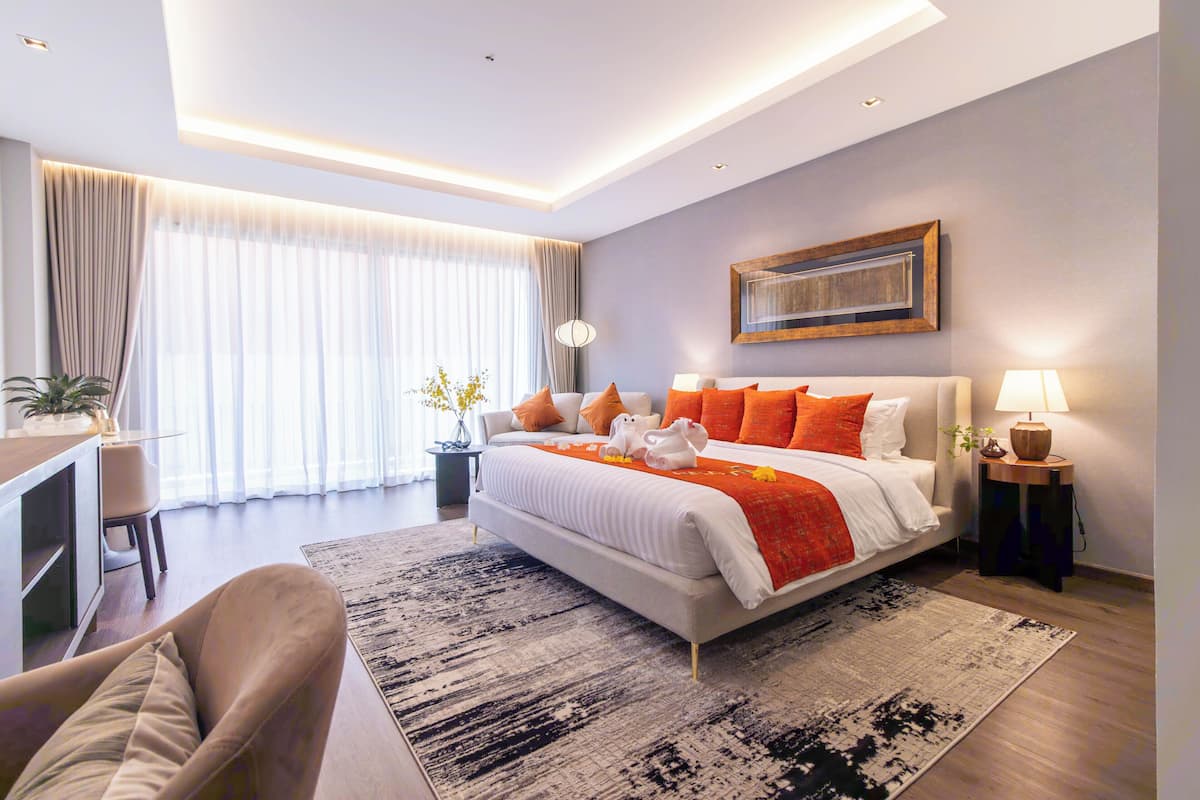 Una habitación de hotel moderna con una cama grande, un escritorio y una silla.