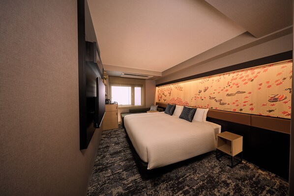 Una habitación de hotel con una cama grande, televisión, escritorio y ventana.