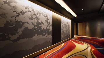 A hallway with patterned walls, a carpet with abstract designs, and a door labeled '7'.