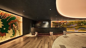 A reception area with a modern design, featuring a wooden floor, a reception desk, and a large decorative wall with a dragon motif. - ANCHORED by RIHGA OSAKA NAMBA (Osaka)