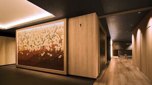 A hallway with wooden flooring, a large abstract wall art, and a number '1' on a wall. - ANCHORED by RIHGA OSAKA NAMBA (Osaka)