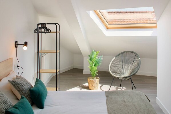 A bedroom with a bed, a hanging chair, a plant, a ladder, and a skylight. - Sobrecantu 644D3 Apartments by R2R Consulting (Oviedo)
