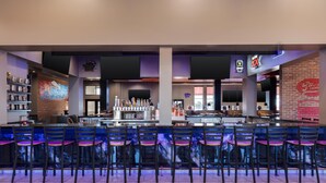 Zona de bar con diversas opciones de asientos y una barra.