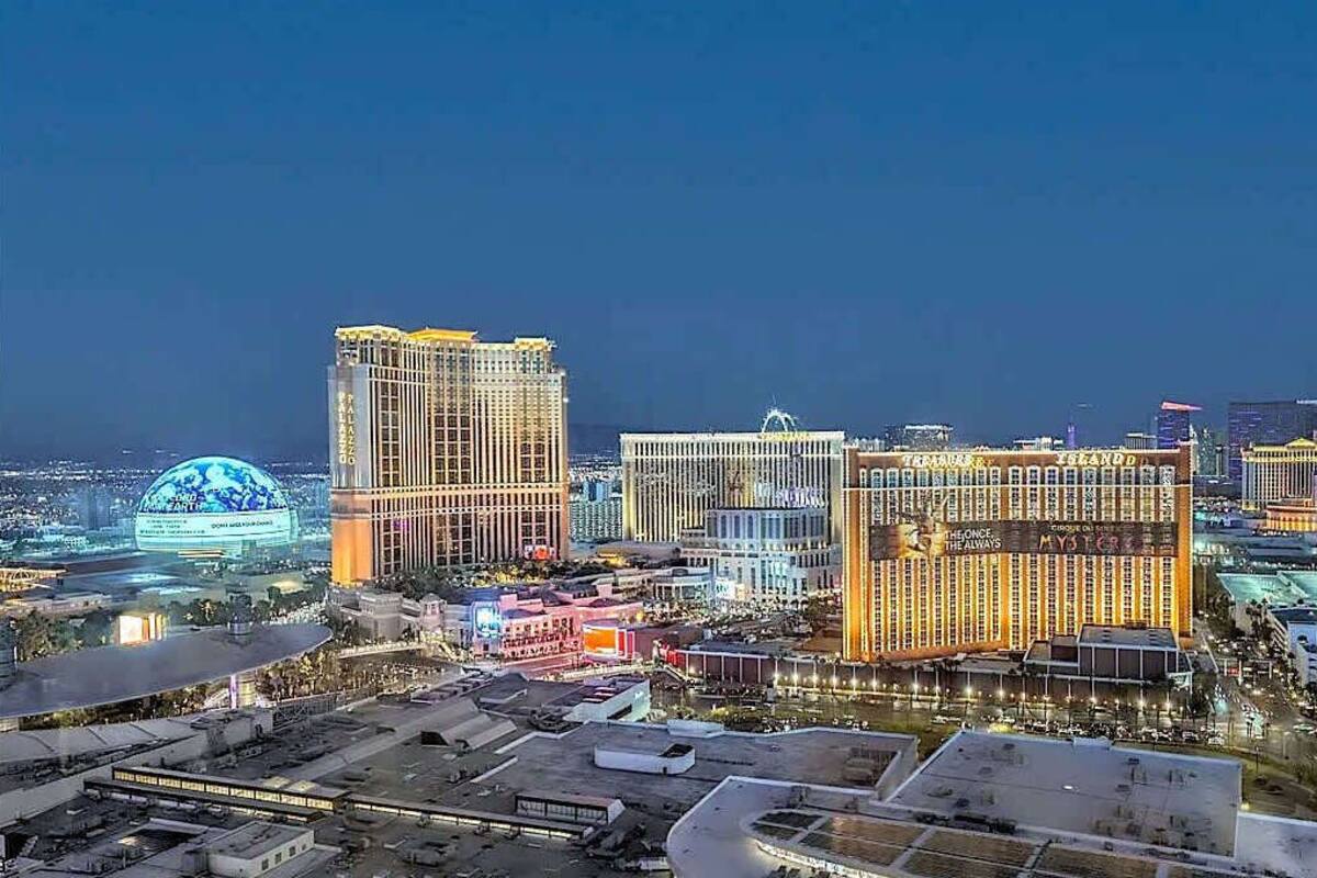 Un paisaje urbano al anochecer con imponentes edificios altos, incluyendo un casino con letreros iluminados.