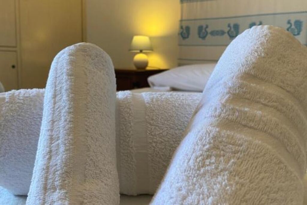 Ein Hotelzimmer mit einem Bett, das mit weißen Handtüchern bezogen ist.
