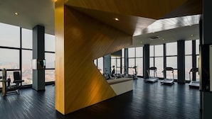 A modern gym with large windows, exercise equipment, and a wooden accent wall. - Expressionz Suites by Manhattan Group  (Kuala Lumpur)