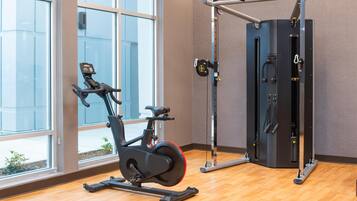 A gym with an exercise bike, a pull-up bar, and a weight machine.