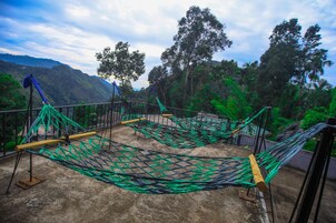 Una hamaca instalada en una azotea con vistas a un paisaje montañoso.