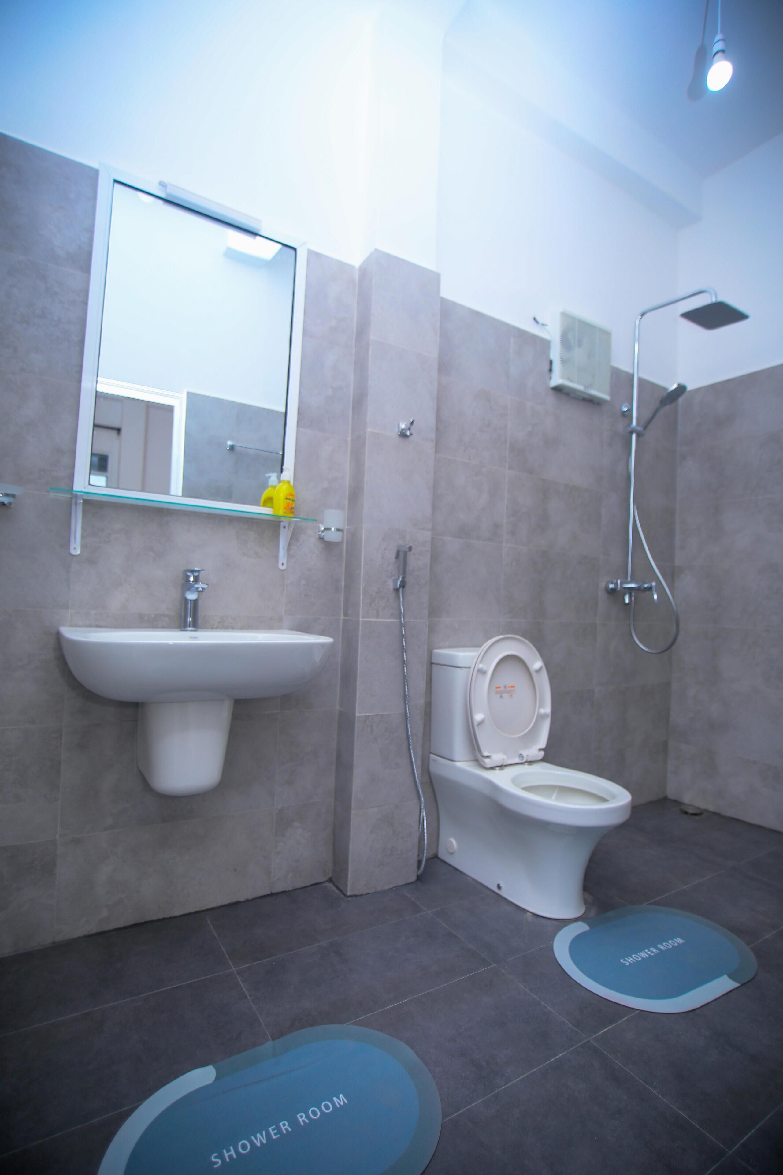 A modern bathroom with a sink, toilet, and shower.
