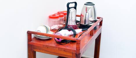 Una mesa de madera con una tetera, una licuadora y recipientes.