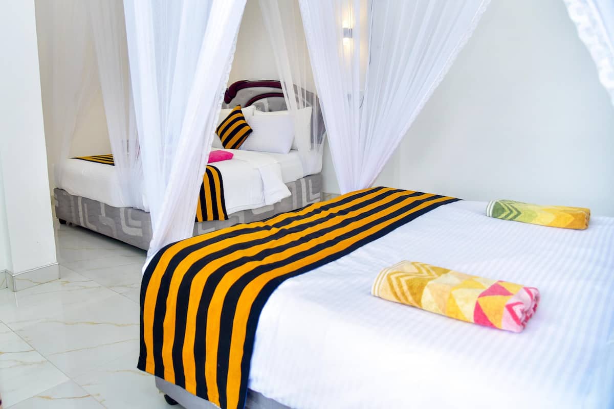 A hotel room with a bed, a bedside table, and a chair.