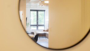 Un intérieur moderne avec une grande fenêtre, des tables rondes et un design minimaliste.