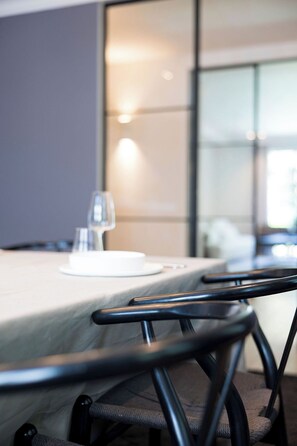 A conference table with a white plate and a glass, and black chairs with a woven seat. - The haven (St. Genesius-Rode)