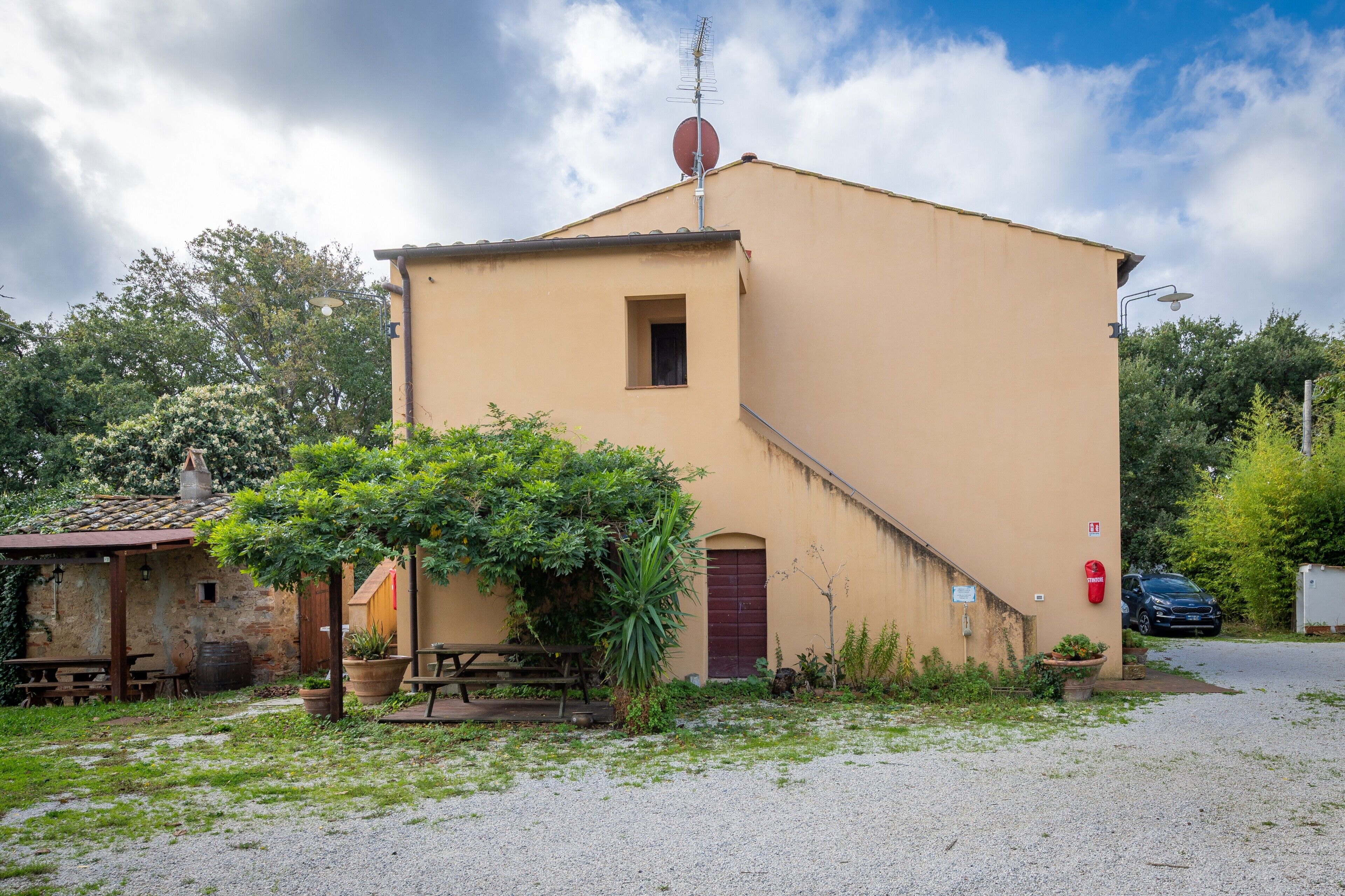 A single-story building with a small window, a door, and a satellite dish on the roof.