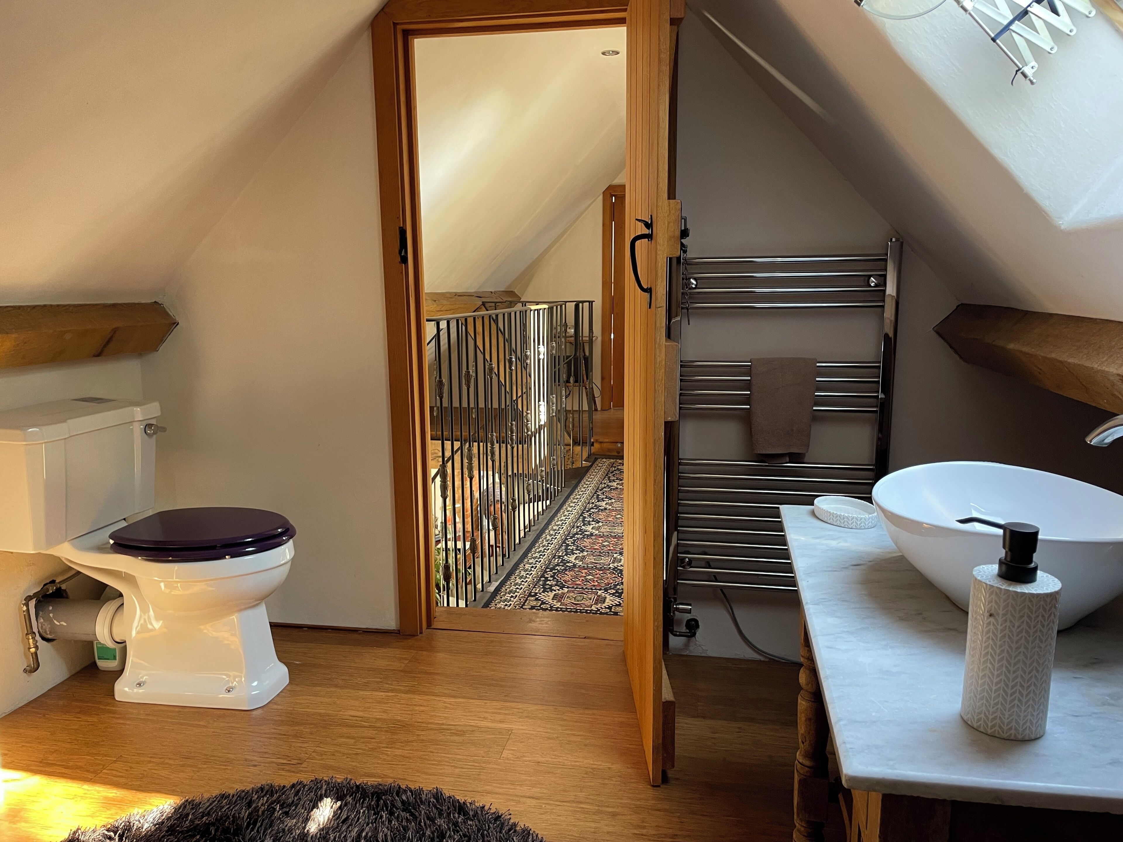 Een kleine badkamer met toilet, wastafel en handdoekhouder.