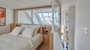 Une chambre moderne avec un grand lit, une fenêtre de toit et une vue sur la ville.
