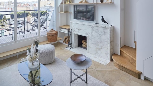 Un appartement moderne de style « loft », doté d’une grande verrière, d’une cheminée et d’un escalier en bois.