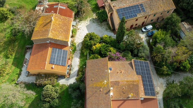 Vue aérienne d’un quartier résidentiel, avec des maisons dotées de toits en tuiles et de panneaux solaires.