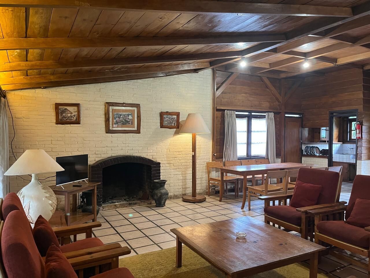 A cozy living room with a fireplace, wooden furniture, and a television.