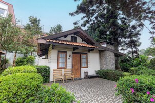 Una pequeña casa con fachada de piedra, techo de tejas y puerta de madera.