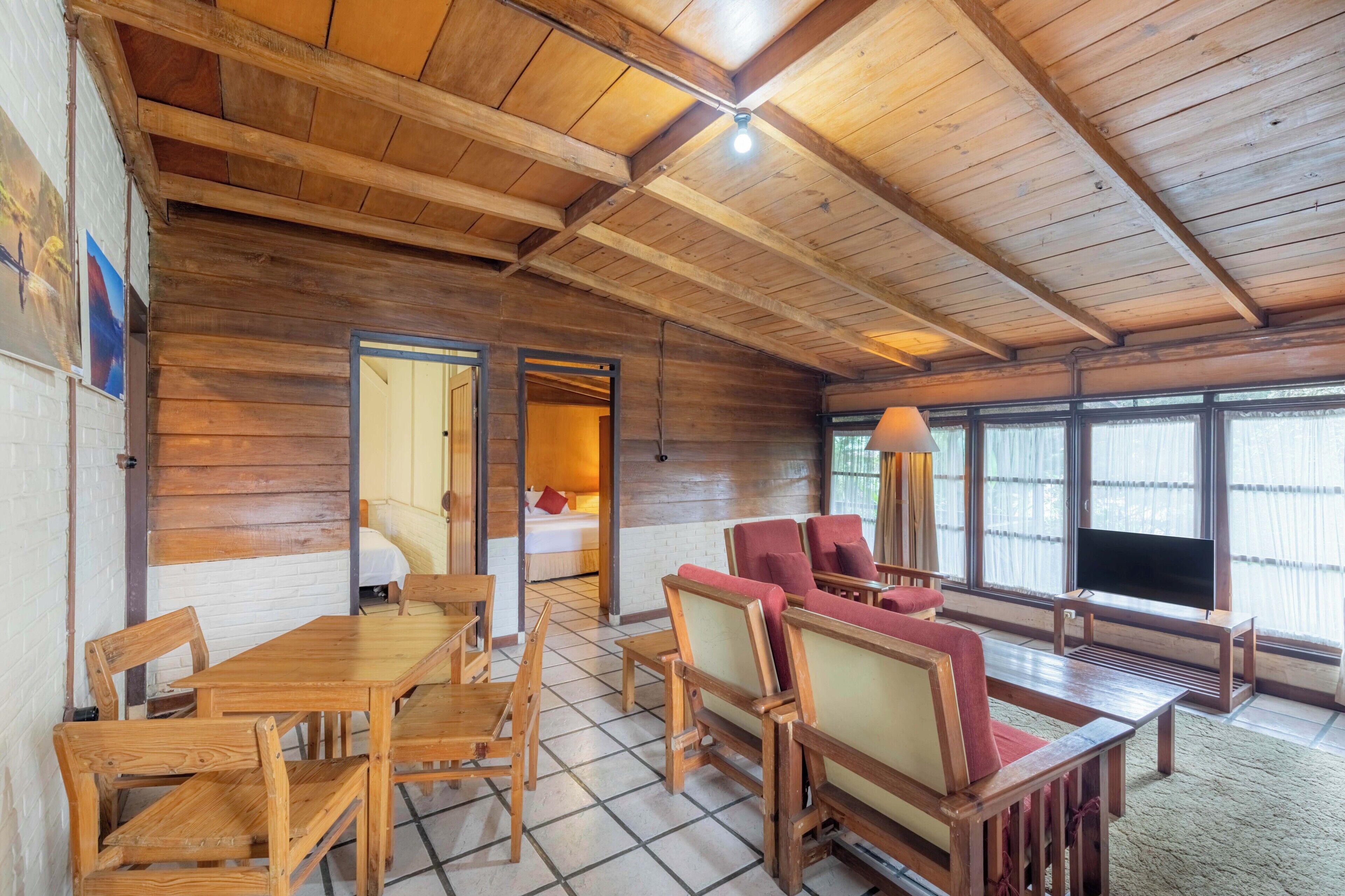 Un interior de madera con comedor, asientos y televisor.