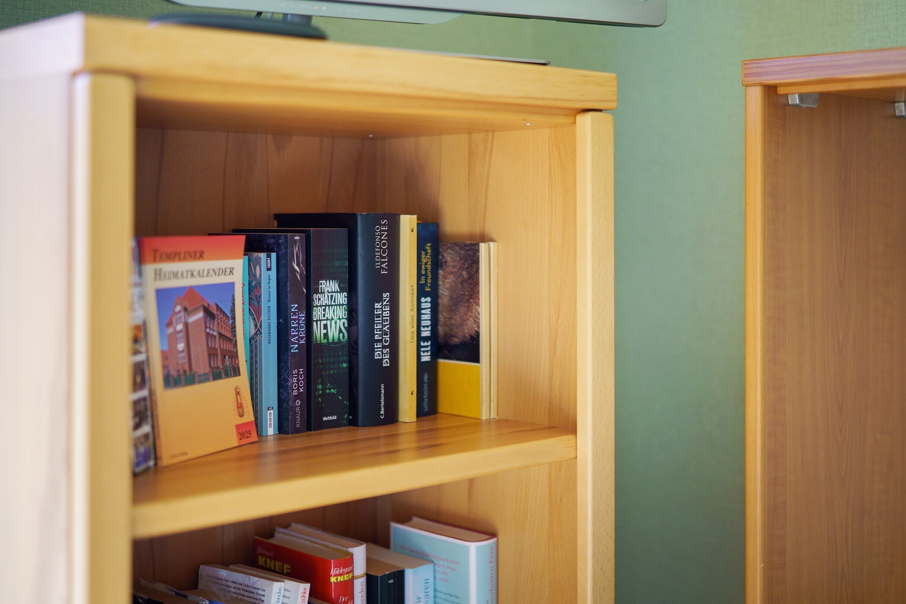 A wooden bookshelf with books and a closed door.