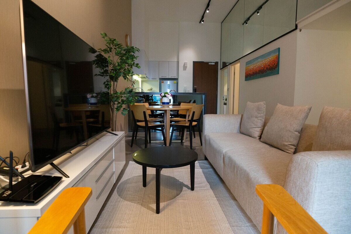 A compact living space with a sofa, a dining table, and a TV.
