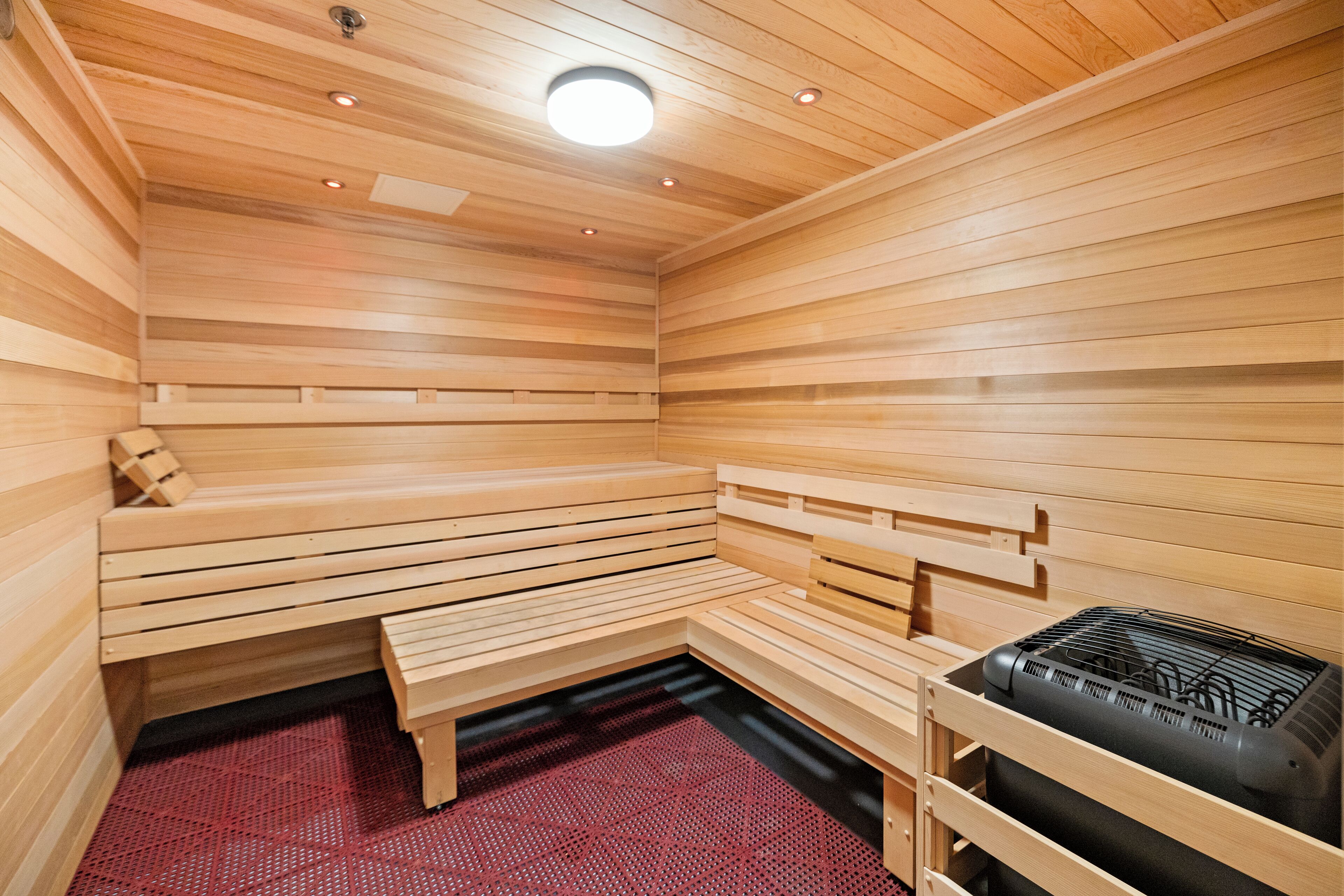 A sauna with wooden benches and a heating unit.
