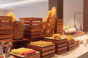A bakery display with bread, pastries, and a woven basket.