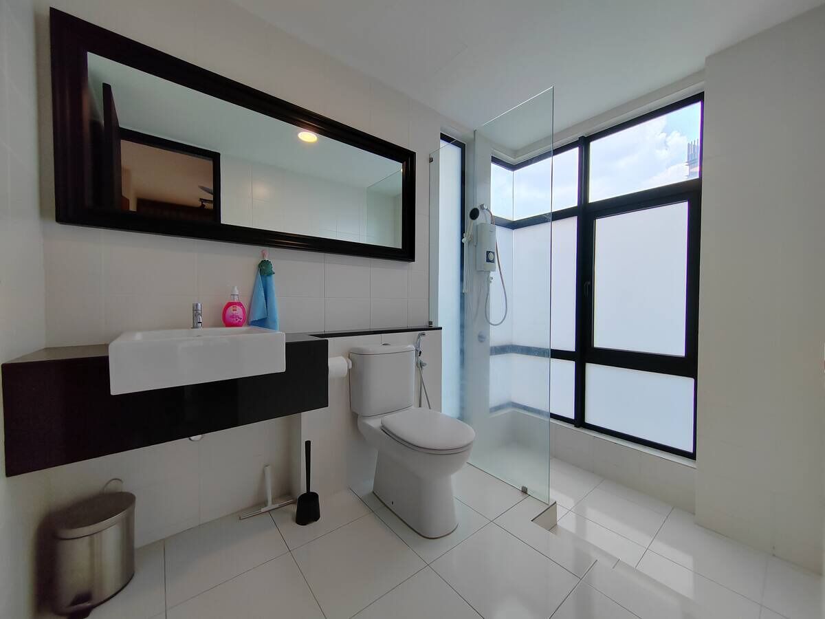 A modern bathroom with a large window, a toilet, a sink, and a mirror.