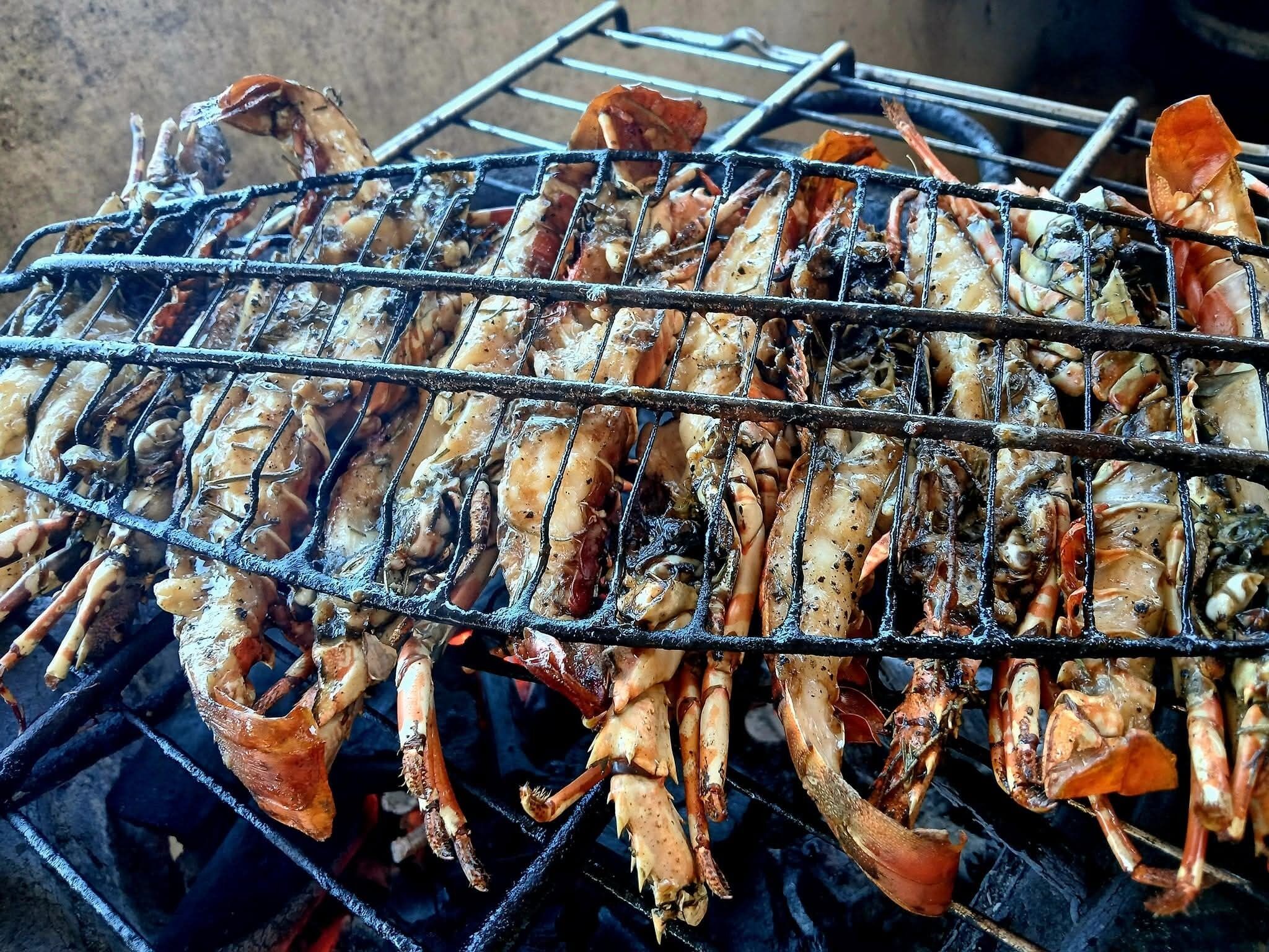 Una parrilla con diversos mariscos cocinándose.