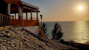 A coastal building with a stone staircase leading to a wooden deck overlooking the sea. - Hotel Mira d'Or amboaboaky toliara (Toliara)