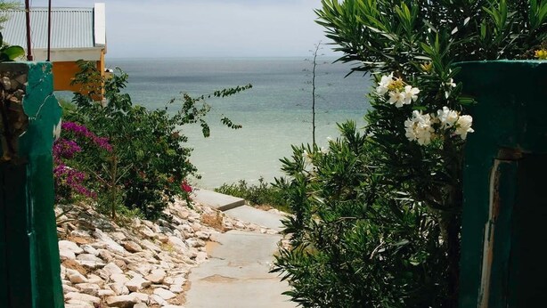 A pathway leading to a beach with a clear view of the sea, surrounded by greenery and a building with a white roof. - Hotel Mira d'Or amboaboaky toliara (Toliara)