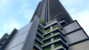 Un edificio de gran altura con varios balcones, algunos con plantas.